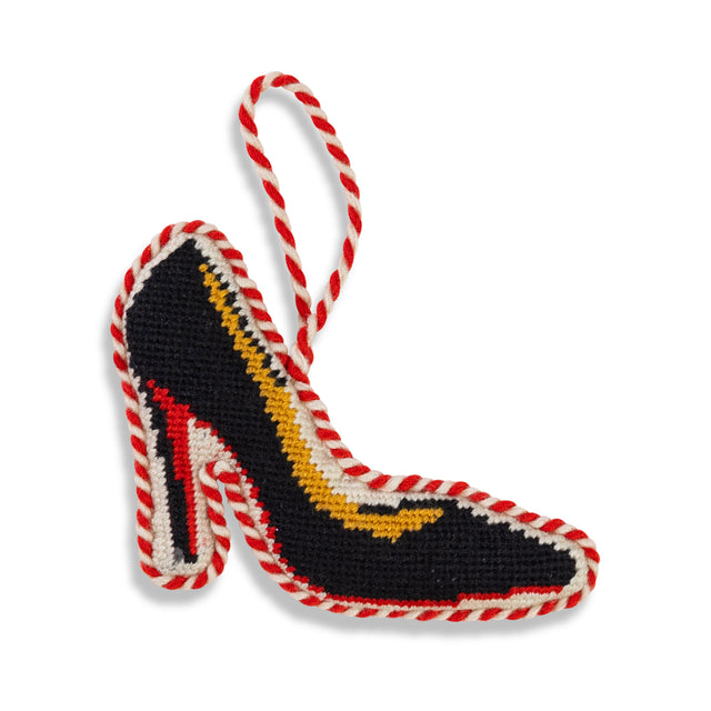 Decorative high-heeled shoe ornament with red and white rope on a white background