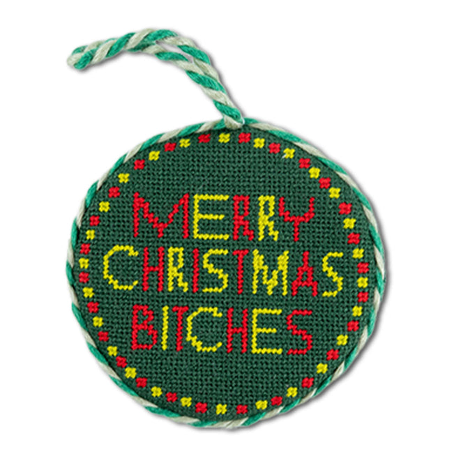 Round green needlepoint ornament with colorful text on a white background