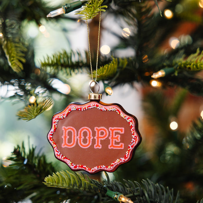 Decorative ornament with 'DOPE' text on a Christmas tree