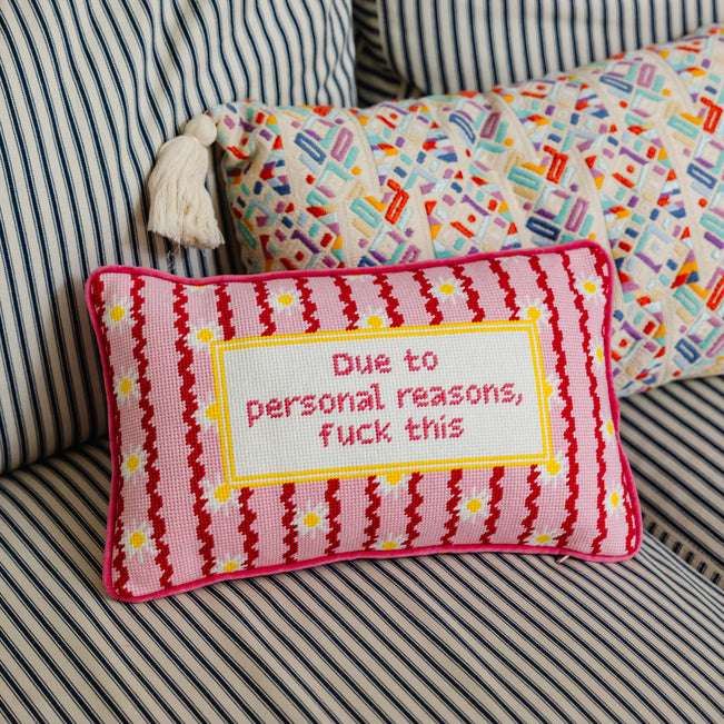 Decorative pillow with text on a striped sofa