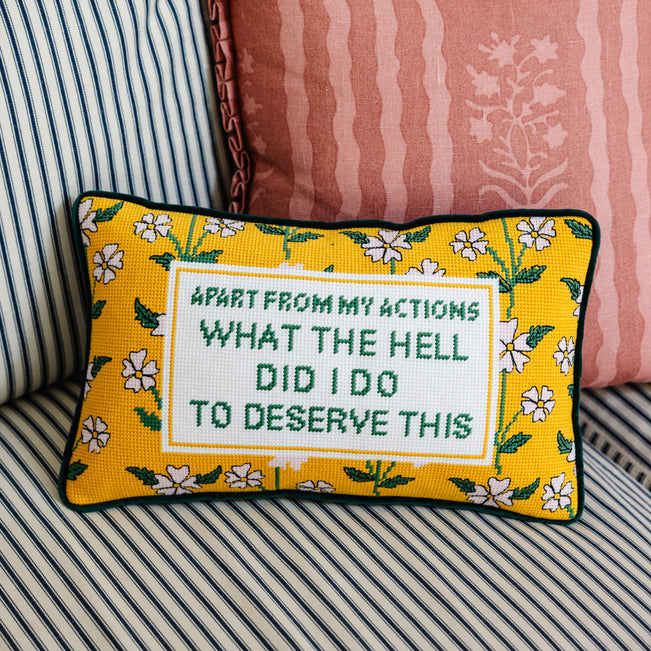 Decorative pillow with text and floral pattern on a striped sofa