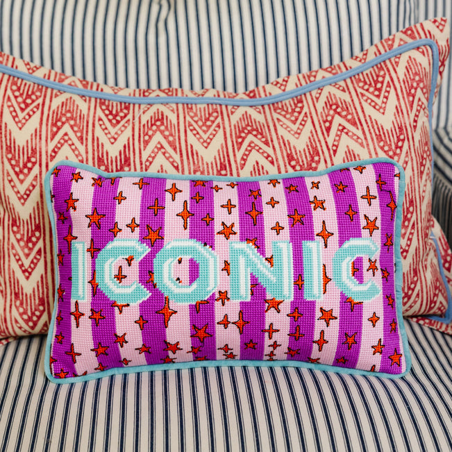 Decorative pillow with 'ICONIC' text on a striped background