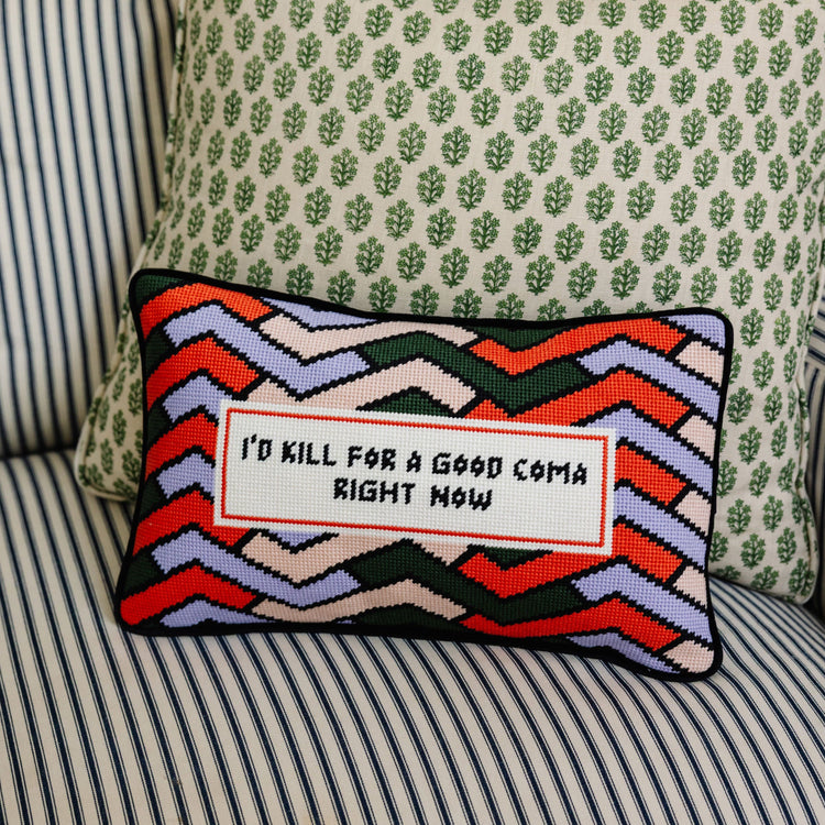 Decorative pillow with colorful zigzag pattern and text on a striped sofa.