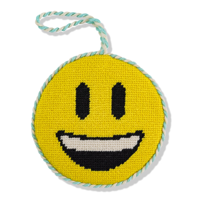 Round yellow smiley face toy with black eyes and mouth, on a white background