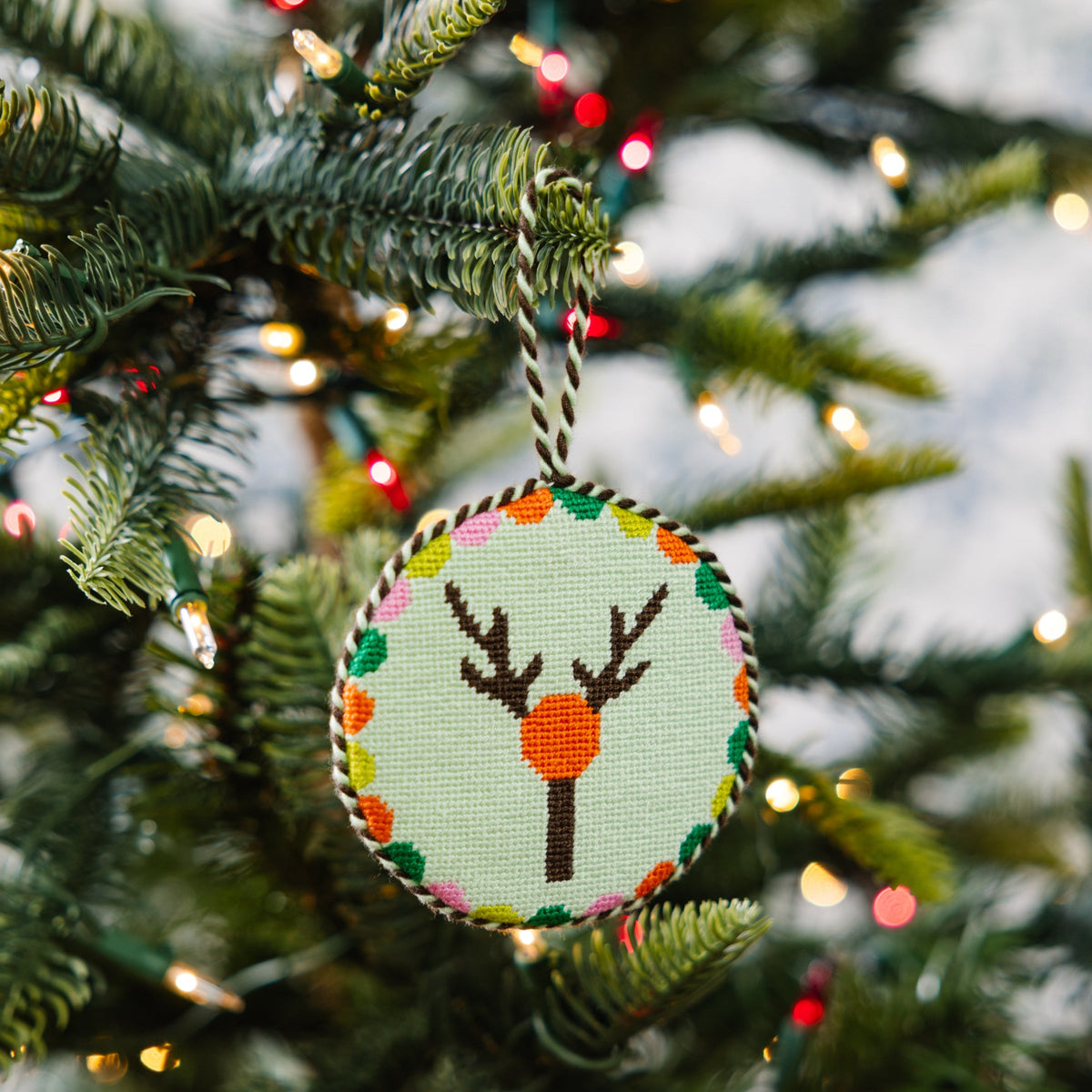 Decorative Christmas ornament with a deer design on a Christmas tree.