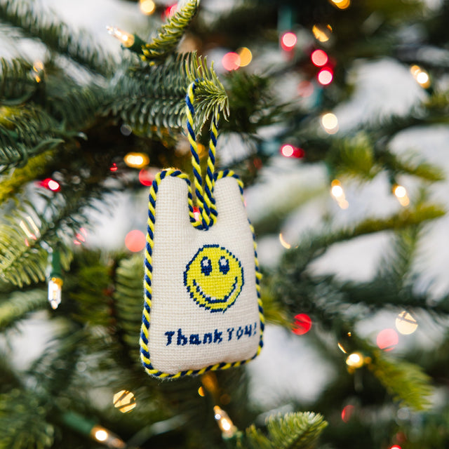 Decorative ornament with smiley face and 'Thank You' text on a Christmas tree.