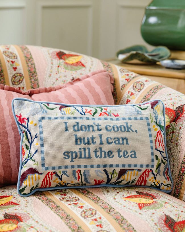 Decorative pillow with floral design and text on a patterned sofa.