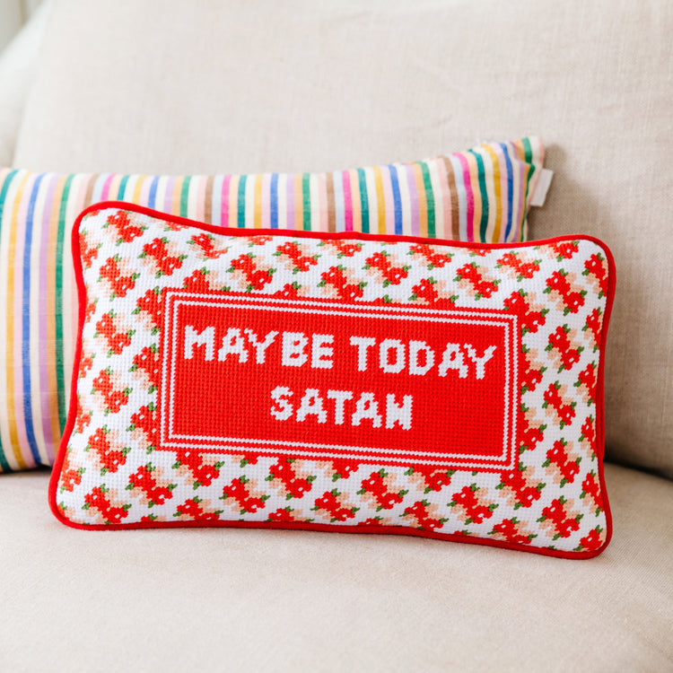 Decorative pillow with 'MAYBE TODAY SATAN' text on a beige couch.