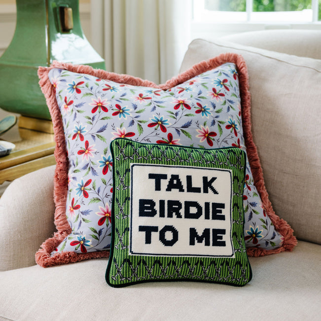 Decorative pillows on a couch with one reading 'Talk Birdie To Me'.