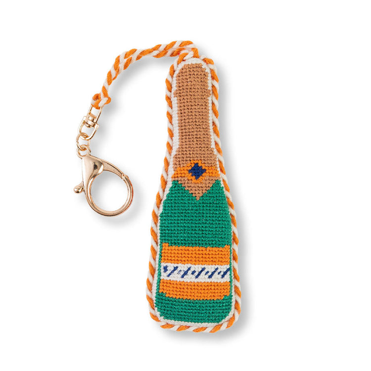 Crocheted champagne bottle keychain with orange and green design on a white background