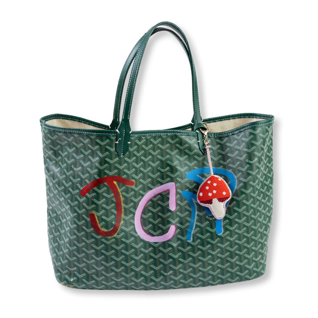 Green patterned tote bag with colorful initials and a mushroom charm on a white background