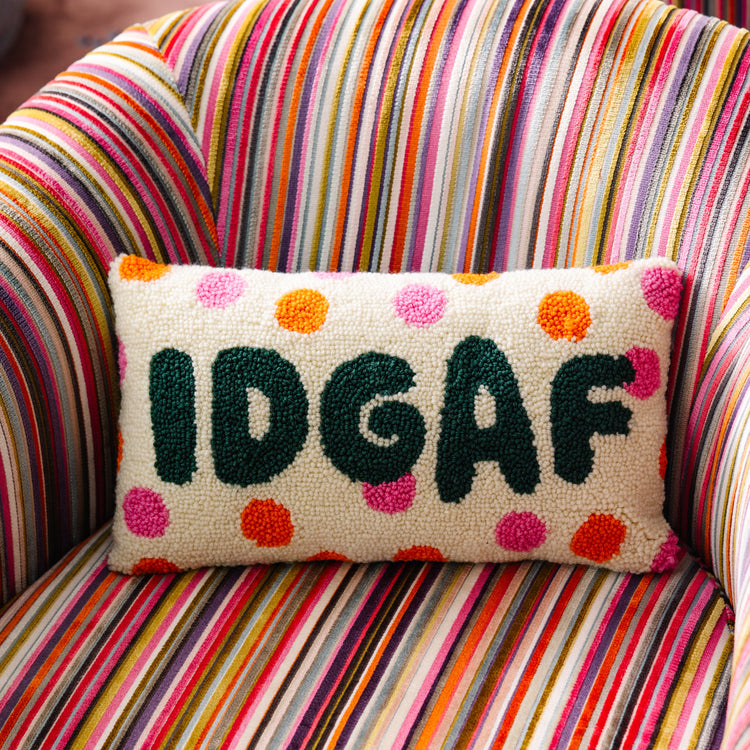 Decorative pillow with 'IDGAF' text on a colorful striped chair
